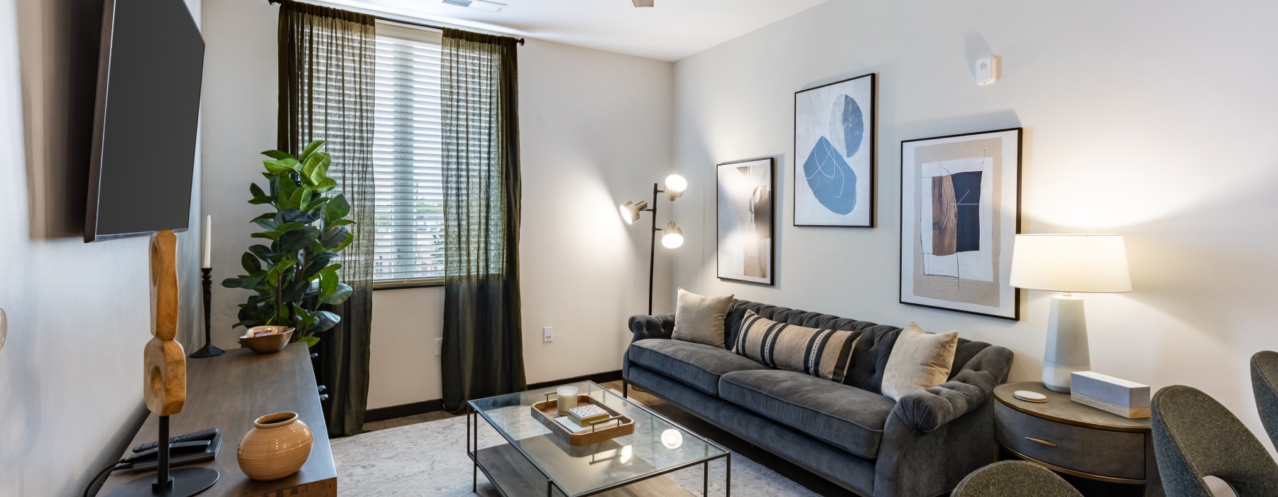 furnished living room with window, ceiling fan and light fixture