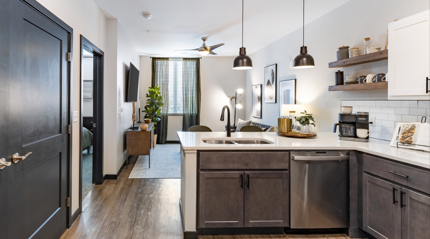 Kitchen view into the livingroom with grey cabinets and white walls